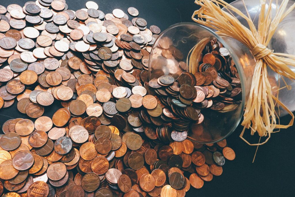 IMAGE - Glass bottle with coins spilling out